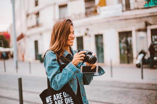Young woman taking photos with a camera outdoors.