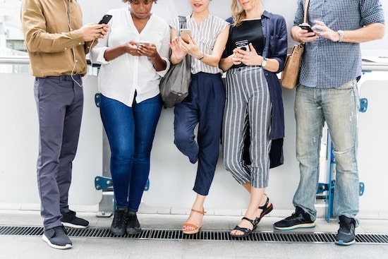 People using smartphones for visual search and shopping in a modern airport setting.