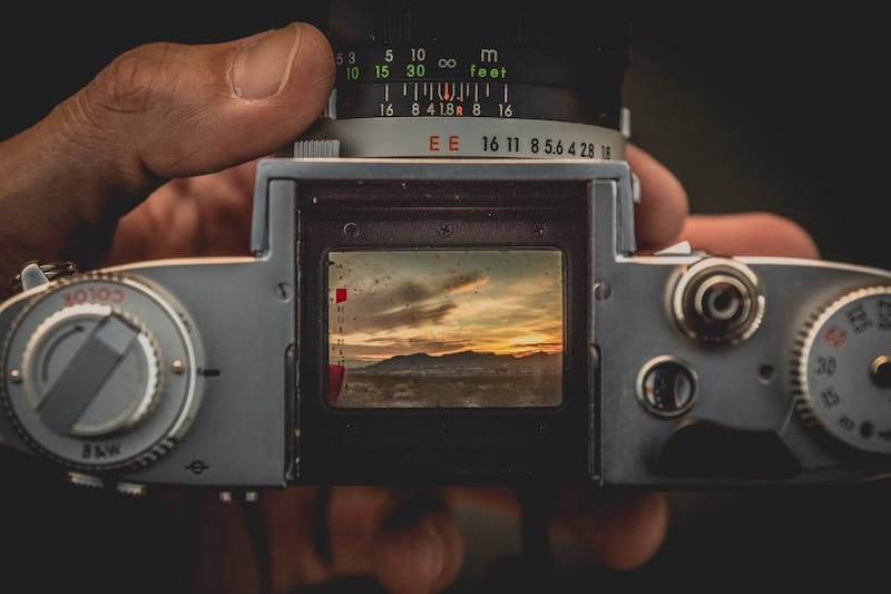 Vintage camera capturing a sunset landscape.