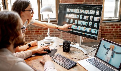 a couple of people are editing pictures o a screen