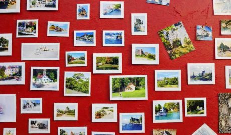 Photo collage of scenic landscapes and urban scenes on a vibrant red wall.