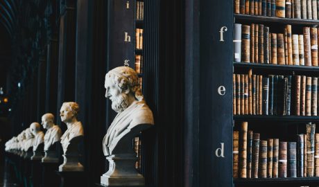 Bust sculptures and vintage books in a historic library setting.