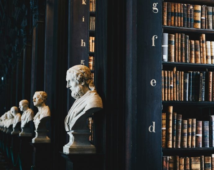 Bust sculptures and vintage books in a historic library setting.