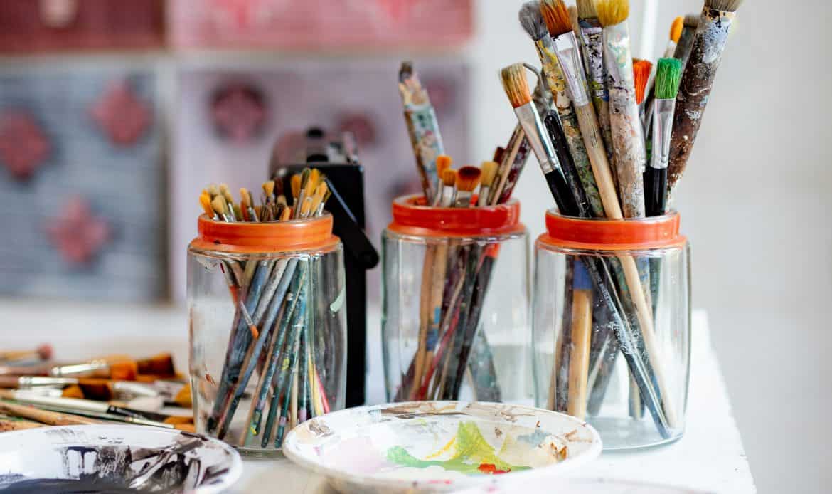 Art brushes and paints on a creative workspace for artistic expression.