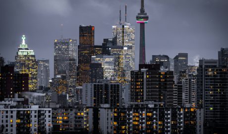Night view of Toronto skyline with illuminated buildings and CN Tower.