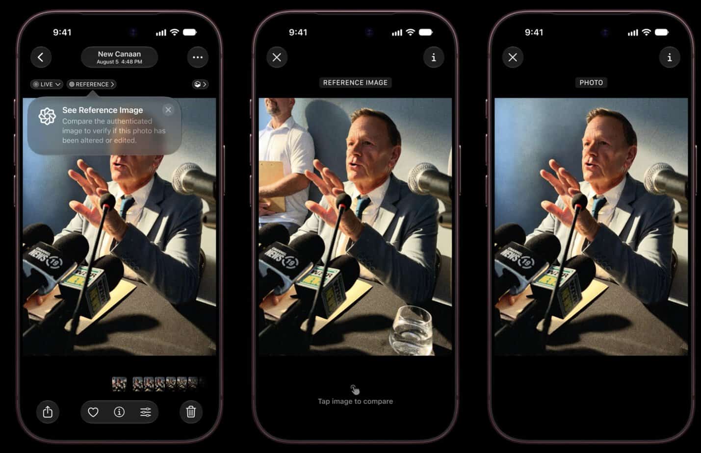 Person speaking at a press conference with microphones and a reference image on screen.